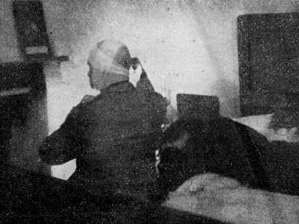 Fotografia di dubbia autenticità, ma utile come ricostruzione. Mussolini seduto sul letto della stanza di casa De Maria, 28 aprile 1945. Riconoscibile sul capo un inizio di fasciatura. L'altro corpo riverso sul letto corrisponderebbe a quello della Petacci, ma l'abbigliamento non corrisponde a quello di Piazzale Loreto. Se fosse autentica sarebbe l'ultima foto di Mussolini da vivo.