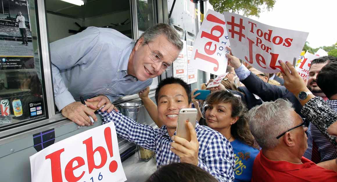 Former Florida Gov. Jeb Bush, upper left, poses for a selfie with a supporter as he signs autographs from the window of a food truck after he formally announced that he would join the race for president with a speech at Miami Dade College, Monday, June 15, 2015, in Miami. (AP Photo/Wilfredo Lee)