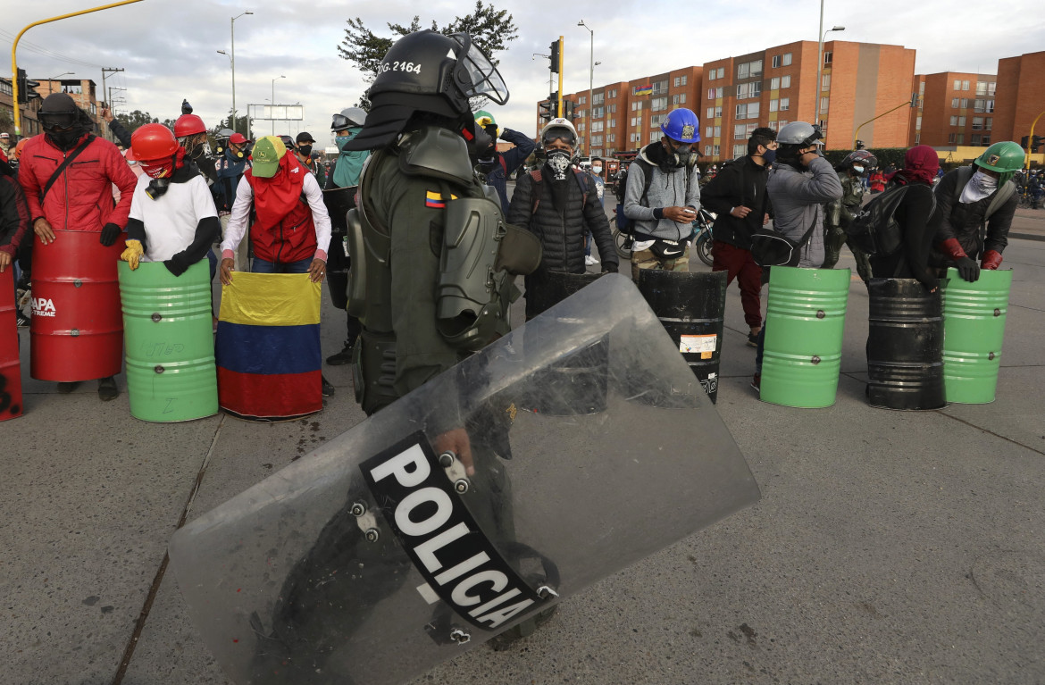 18 maggio, manifestanti con scudi protettivi autocostruiti durante il blocco di un terminal dei bus a Bogotà