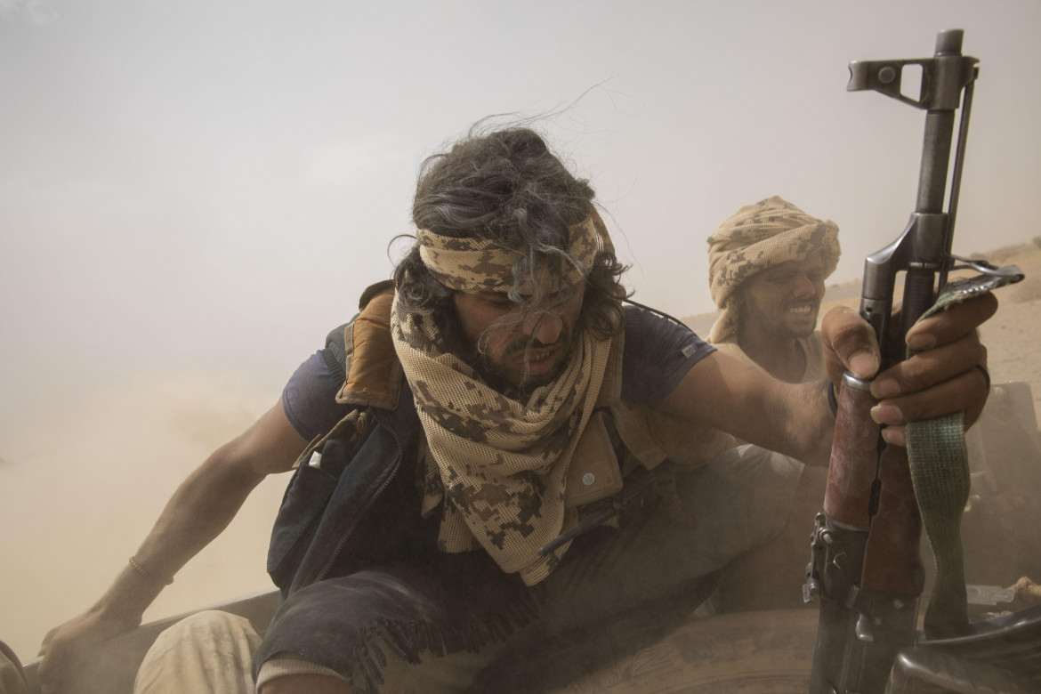 Yemen. Combattenti sostenuti dai sauditi sul retro di un veicolo blindato mentre lasciano le linee del fronte di Marib